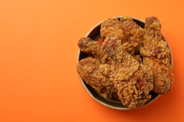 Photo bucket with fried chicken on orange background