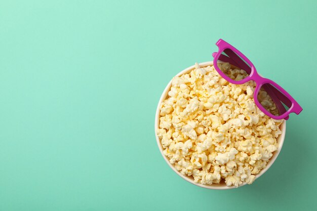 Bucket with popcorn and 3d glasses on mint space