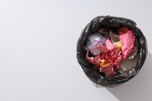 Bucket with trash bag and papers on white background space for text