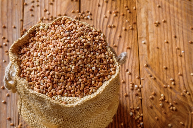 Buckwheat in a bag on a wooden surface