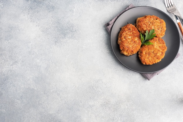 Buckwheat cutlets with cheese and parsley on a plate. Healthy diet food copy space, top view.