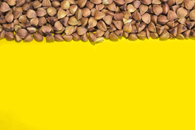 Buckwheat grains on a yellow background. a place for text. healthy food concept