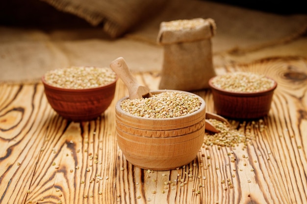 Buckwheat groats in bowls and bags on a wooden background High quality photo