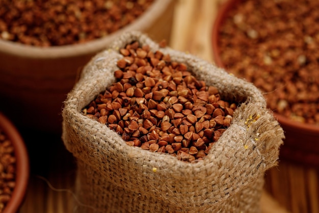 Buckwheat groats in bowls and bags on a wooden background High quality photo