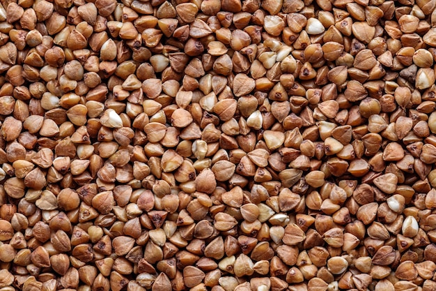 Buckwheat groats in bulk grains closeup background