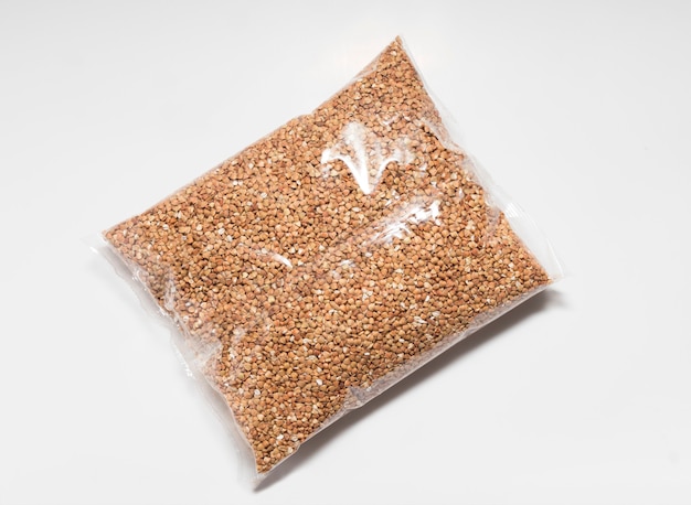 Buckwheat groats in a transparent close-up bag on a white background.