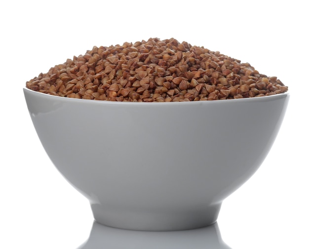 Buckwheat groats in a white bowl on a white isolated background