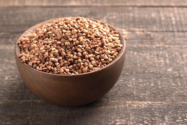 Photo buckwheat groats on wooden background