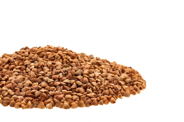 Buckwheat in a heap on the side on a white background.