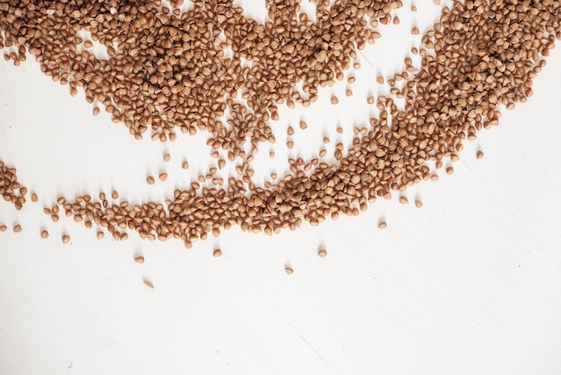 Buckwheat is randomly scattered on a white background