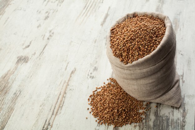 Buckwheat in linen sack into wooden decking.