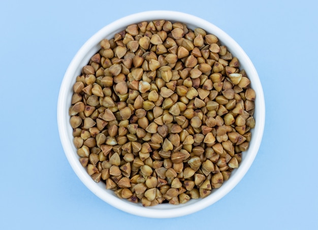 Buckwheat in a plate on blue 