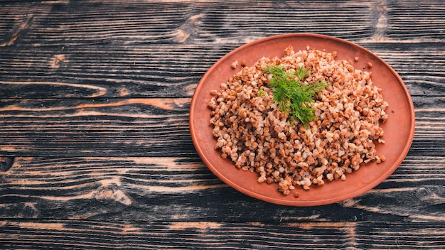 Buckwheat on a plate On a wooden background Top view Copy space