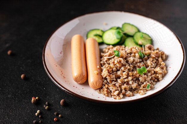 Porridge di grano saraceno e salsicce insalata fresca cetriolo pronto da mangiare spuntino sul tavolo