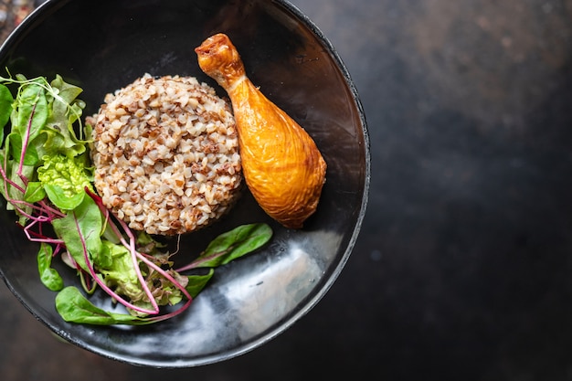 Buckwheat porridge with chicken leg salad leaves green petals lettuce