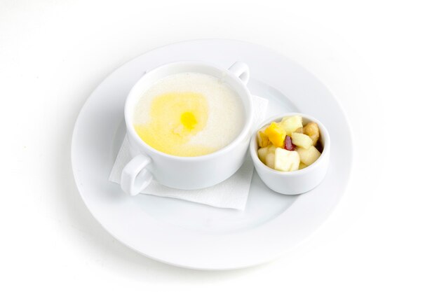 Buckwheat porridge with milk and butter in a white plate on a white background