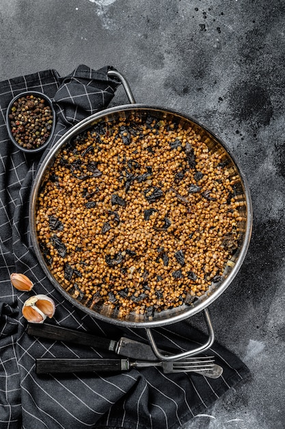 Buckwheat porridge with mushrooms. Vegan food. Russian, Ukranian cuisine. Black background. Top view. Copy space