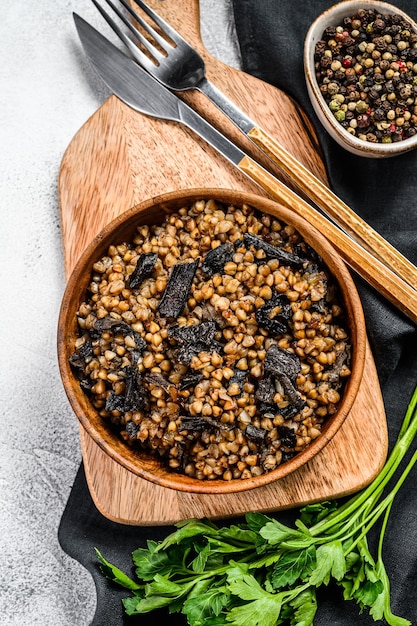 Farinata di grano saraceno con funghi in una pentola di legno