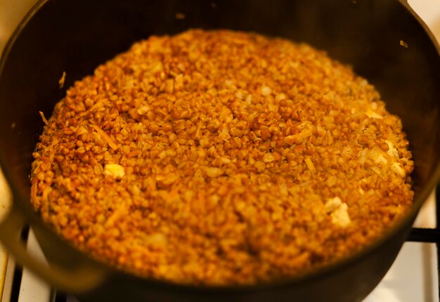 Foto porridge di grano saraceno con pezzi di carne in una casseruola. primo piano