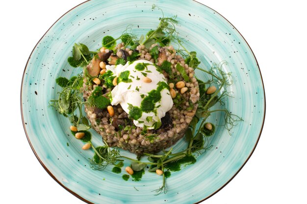 Buckwheat porridge with poached egg and fried mushrooms decorated with celery a wonderful restaurant dish