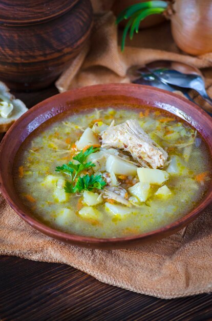 Buckwheat soup with meat in a clay bowl on the table closeup