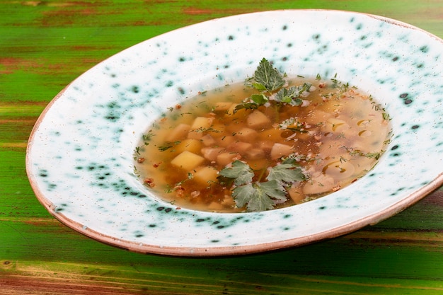 Buckwheat soup with porcini mushrooms On a colored wooden background Vegetarian dish