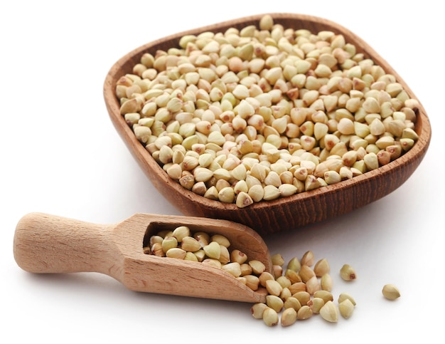 Buckwheat with bowl and wooden spoon over white background