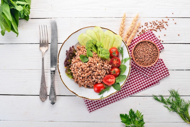 Buckwheat with cucumber broccoli and tomatoes On a wooden background Top view Copy space