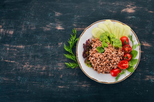 Buckwheat with cucumber broccoli and tomatoes On a wooden background Top view Copy space