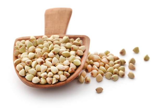 Buckwheat with wooden spoon over white background