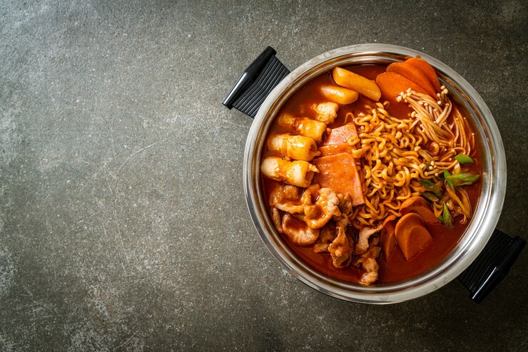 Photo 부대찌개 또는 부대찌개(육군 스튜 또는 육군 기지 스튜). 김치, 스팸, 소세지, 라면 등이 가득 들어 있습니다. 한국의 인기있는 냄비 요리 스타일
