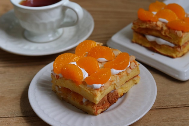 Торт «Будапешт» со сливками, покрытый свежим мандариновым апельсином