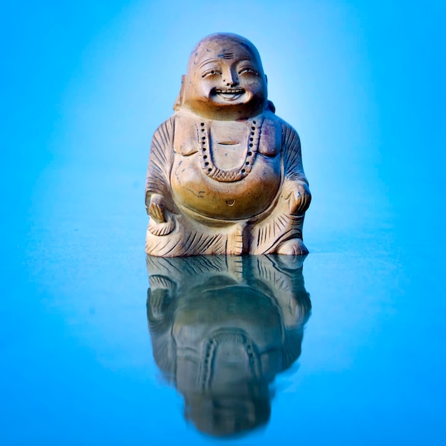 Budda statuette on the beach Blue waves in the background