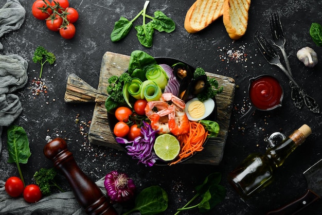 Buddha bowl of seafood Shrimp mussels cabbage cherry tomatoes spinach Seafood dishes Top view Free space for your text