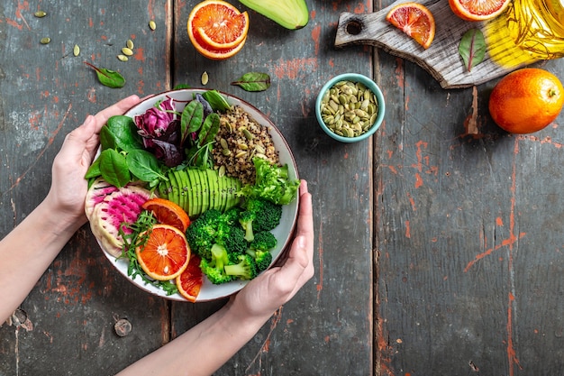 buddha bowl with fruit, vegetable and seeds on a blue background. space for text. top view.