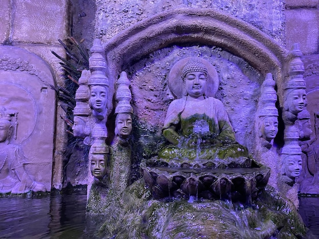 Buddha in meditation with burning candlebamboo leaf and zen stones