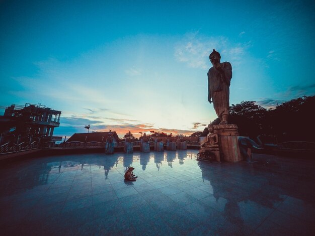 写真 夕暮れの空に照らされた仏像