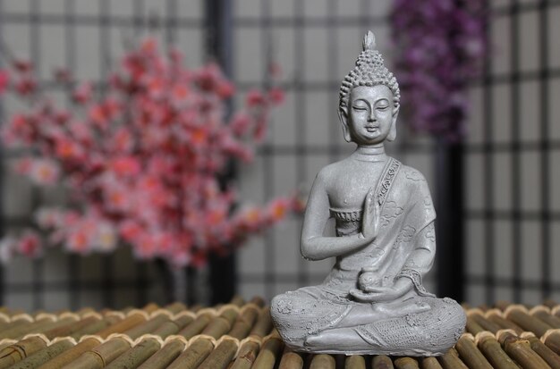 背景に桜の花がくアジア風の仏像の部屋