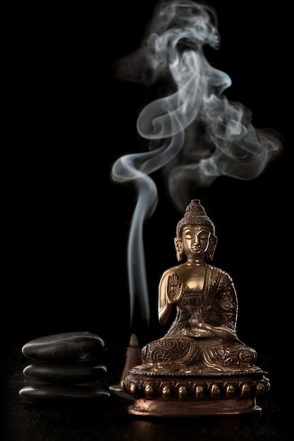 Buddha statue incense and black stones