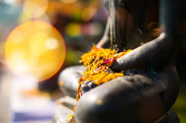 Buddha statue with flowers and leaft in Songkran festival water ceremony