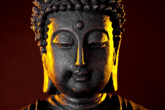 Buddha statue with glow against black background