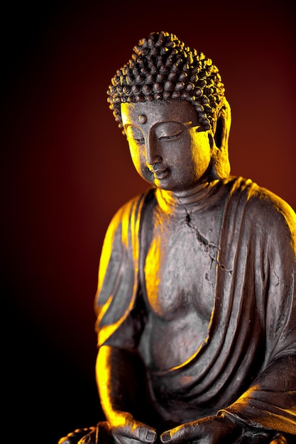 Buddha statue with glow against black background