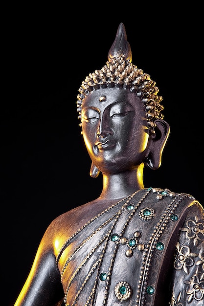 Buddha statue with glow against black background