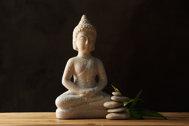 Buddha and stones on bamboo background. Zen concept