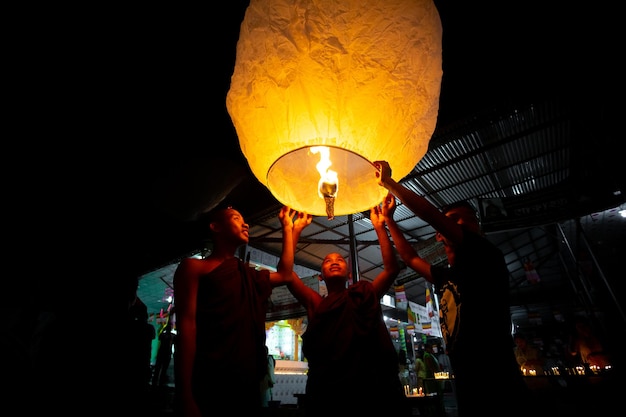 Photo buddhist devotees people are trying to flying paper lanterns on the occas