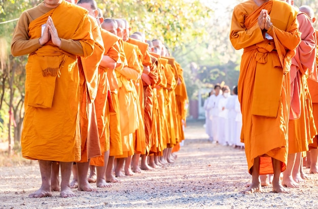 Photo buddhist monk is standing with his hands folded in the shape of a lotus to perform some religious ritual uniform buddhist monk buddhist monk praying