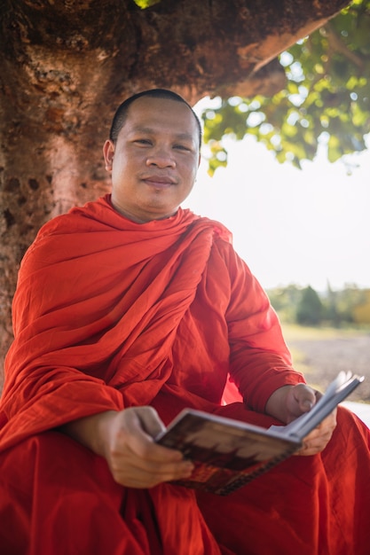 Buddhist monk reading outdoors.