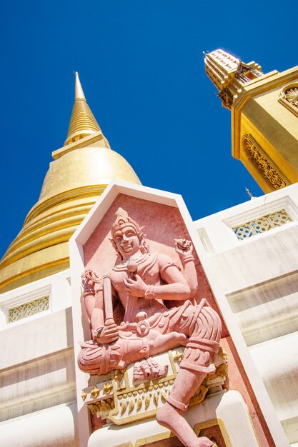 Buddhist sculpture with pagoda in the background. Temple of Bangkok, Thailand. Buddhist concept