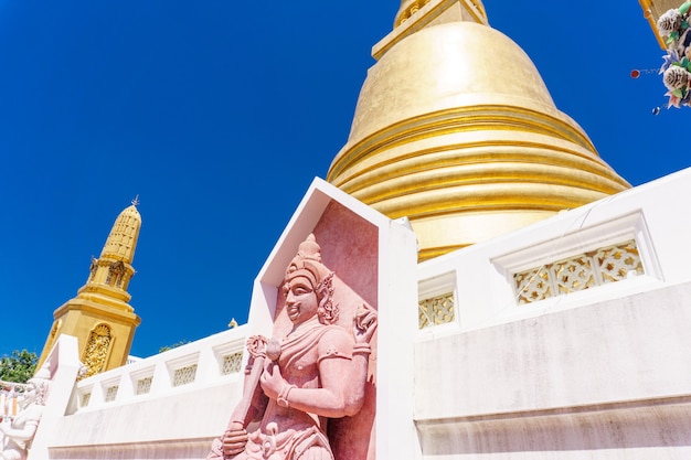 Фото Буддийская скульптура с пагодой на заднем плане. храм бангкока, таиланд. буддийская концепция