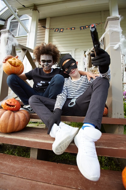 Buddies with Halloween costumes sitting on stairs